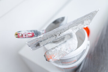 Plastering tools with wall putty on bucket during renovation © zphoto83