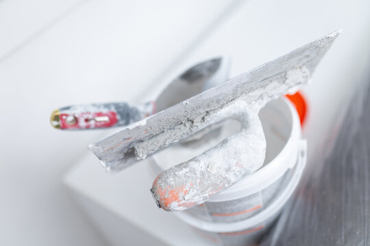 Plastering tools with wall putty on bucket during renovation