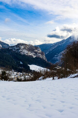 Fototapeta premium Village of Rencurel and its church covered in snow in winter in the Vercors massif