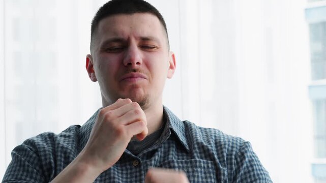 A man in a shirt yawns in the morning.
The man didn't get enough sleep and yawns at work.