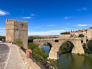Obraz premium Alcantara bridge and tower spanning Tagus river in Toledo, Spain