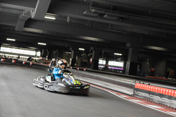 A thrilling indoor go-kart race captures the excitement and speed of karting in an urban setting. © Dejan