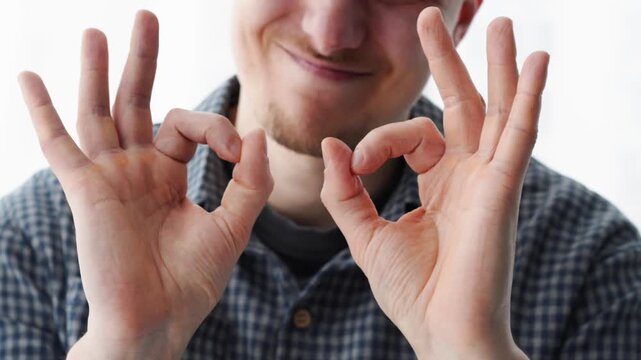 A happy man shows that everything is fine. Everything is great.
Okay with his fingers.
Body language.