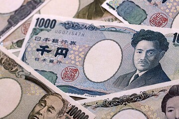 Japanese yen money bills pile on table. Japan banknotes of JPY currency close up © Larysa