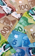 Fototapeta premium Canadian dollar money bills pile on table. Canada banknotes of CAD currency close up. Concept of business, economy and investment in Canada