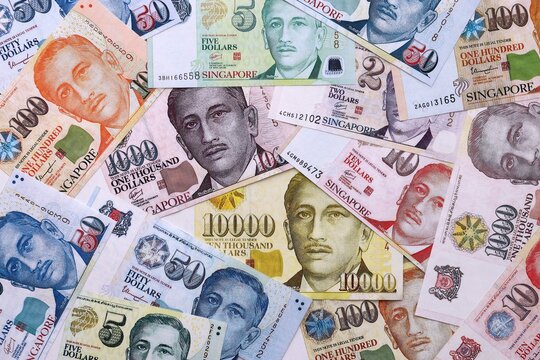 Singapore dollar money bills pile on table. Singapore banknotes of SGD currency close up