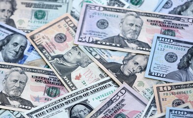 Fototapeta premium US dollar money bills pile on table. United States banknotes of USD currency close up