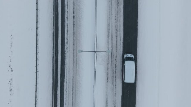 Aerial perspective captures wintertime freight convoy prioritizing timely delivery along snowlined roads