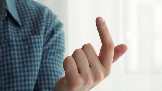 A man gestures with his finger, "Come here."
A man beckons someone to him.
Gestures "Come here."