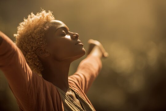 African female joyful young adult with arms outstretched in warm sunlight