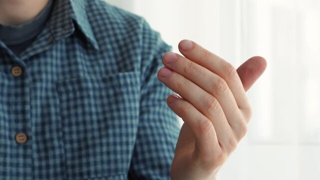 Come here, signal.
The man asks with his index finger to come here.