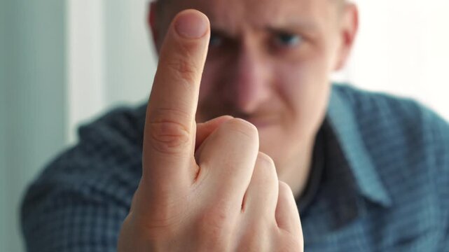 A man gestures with his finger, "Come here."
A man beckons someone to him.
Gestures "Come here."