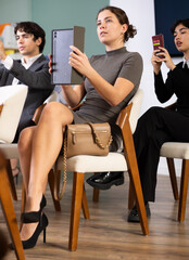Obraz premium Young woman scans QR codes or takes photo of presentation using tablet during meeting in office