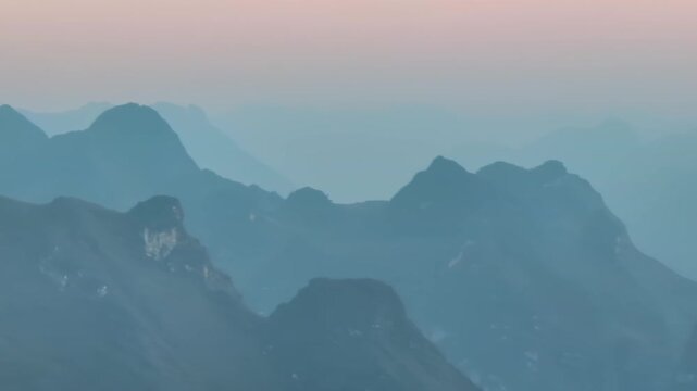 A scenic view of the misty mountains in Ha Giang, Vietnam. The image captures the serene beauty of the landscape at dawn, showcasing the natural beauty of the region.