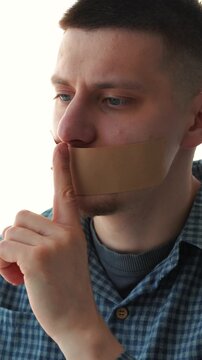 A man makes a silence gesture with his mouth closed.
Silence and secrecy.
Keeping secrets and information