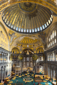 Istanbul, Turkey - October 6, 2025: Wide view of Hagia Sophia&rsquo;s main hall with domed ceilings, giant Arabic calligraphy medallions and rows of glowing chandeliers above the teal prayer carpet