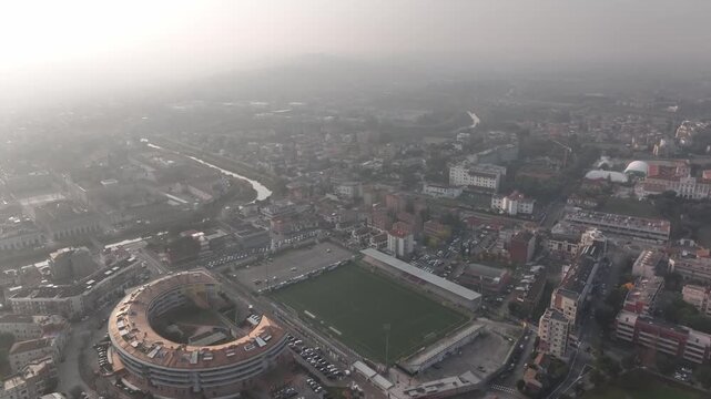 Aerial view of Cingoli, Marche, Central Italy. Morning drone shot with light mist over the historic hilltop town and local stadium, revealing authentic Italian architecture and landscape.