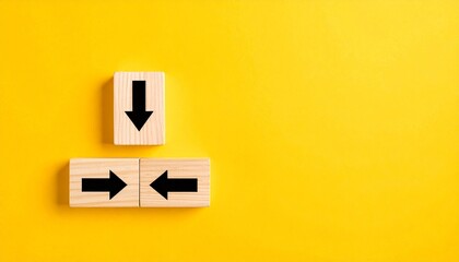 Wooden Blocks with Black Arrows Showing Directional Choices on Bright Yellow Background