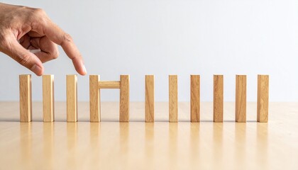 Hand Placing Wooden Block to Stop Domino Effect
