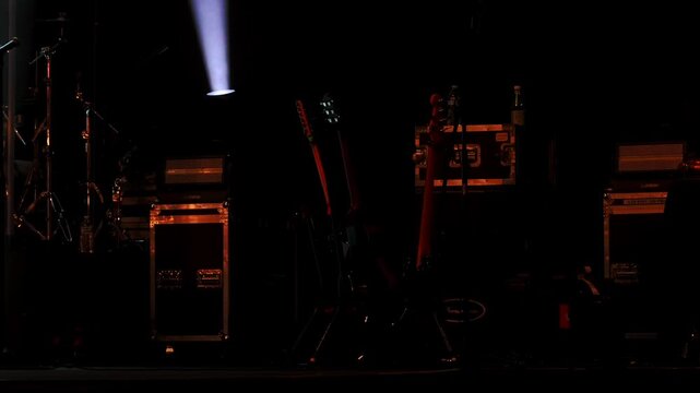 Empty Stage Setup with Guitars Awaiting Performance under Spotlight