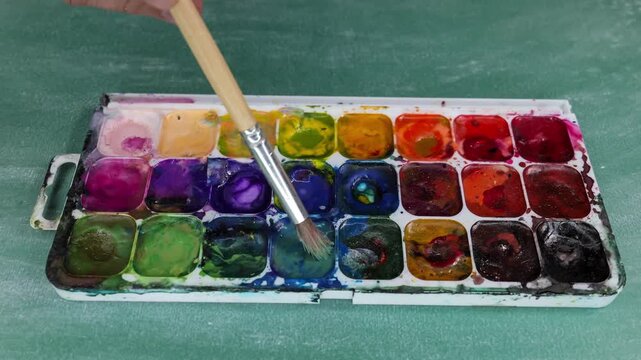 Watercolor Paint Palette With Colorful Pans And Brush On Table