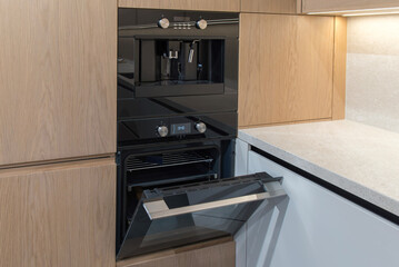 Fototapeta premium Built-in coffee machine and oven in modern minimalist kitchen