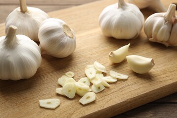 Fresh garlic bulbs and cloves on wooden table, closeup