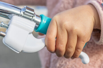 自転車のブレーキを握る女の子の手（顔無し、日本人、5歳）