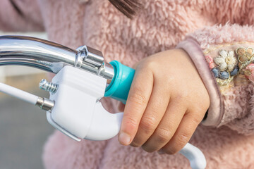 自転車のブレーキを握る女の子の手（顔無し、日本人、5歳）