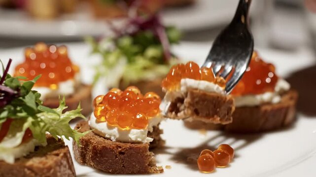 Close-up of red caviar canap&eacute; with fork on white plate