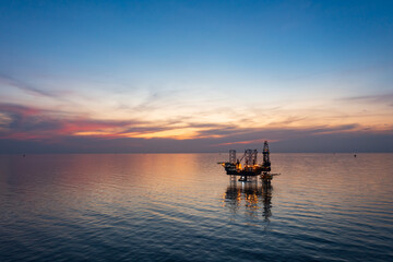 Aerial view of offshore jack up rig in a shipyard during sunset for oil and gas exploration and production.