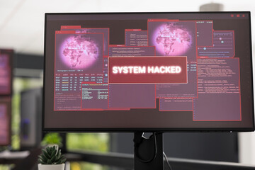 Close up of computer screen in empty office displaying system hack warning messages and critical...