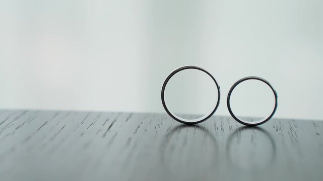 Wedding gold rings captured from an unusual angle, slow motion. Contemporary style