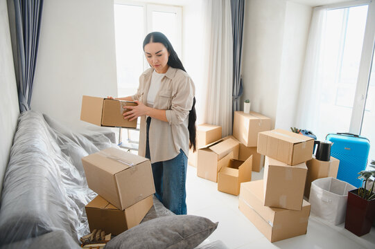 Woman unpacking boxes in new apartment for relocation