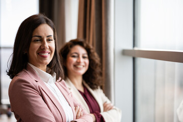 Obraz premium Confident businesswomen smiling in modern office environment