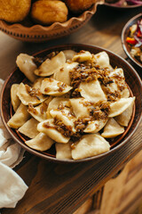 Vareniki with fried onions on traditional ukrainian wooden table