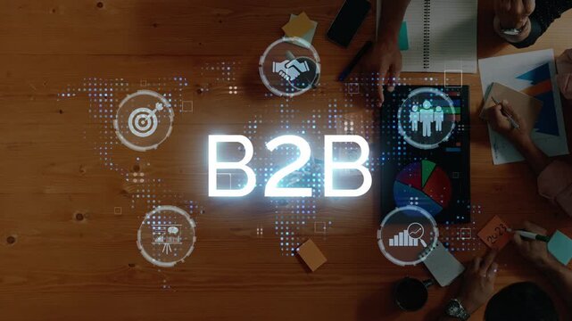 A captivating overhead view capturing a dynamic B2B collaboration scene, showcasing hands engaged in strategic planning with charts, graphs, and digital elements on a wooden table. Raster
