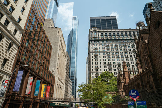 New York City, New York, USA - 08.01.2024: Wall Street in New York City showcases a striking mix of modern skyscrapers and historic buildings. Trinity Church stands alongside glass towers and classic