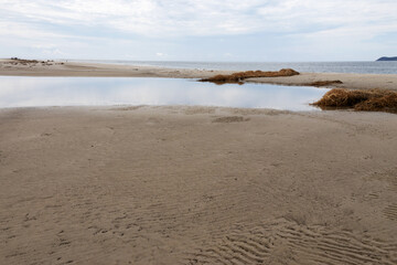 a saltwater lake formed amidst the sand after the tide rises