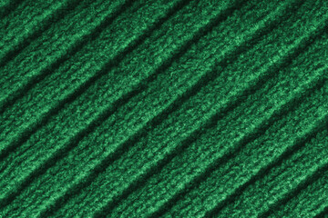 Close up, macro of green colored knitted fabric with diagonal relief ribbed pattern and soft wool texture. Detailed textile surface, knitwear background, fashion, backdrop, design element. © katyamaximenko