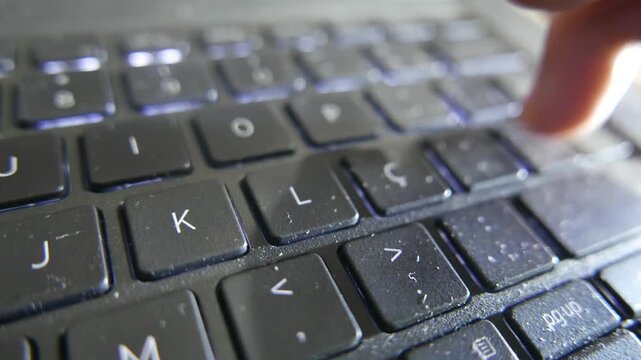 POV of someone typing on a laptop. A person typing on a computer keyboard. A close-up of a laptop keyboard. Computer keys. A dirty keyboard.