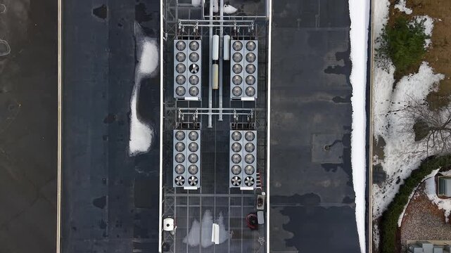 Aerial top down view of rooftop HVAC units including cooling fans and chillers on a small data center.