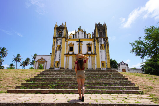 Tourism in Olinda, Brazil. Full length of young tourist woman visiting ruins of the church Igreja Nossa Senhora do Carmo in Olinda, Brazil.