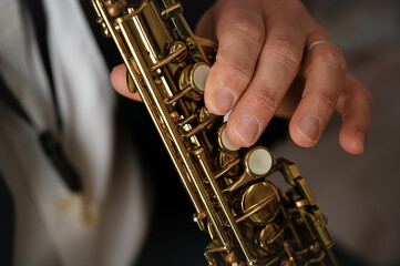Fototapeta premium close up of man's hand playing a soprano sax