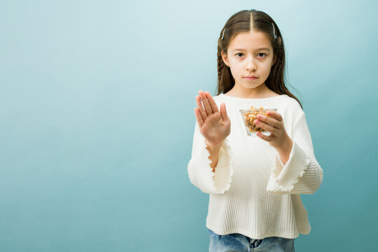 Young girl rejecting walnuts, having an allergic reaction to nuts, suffering from food intolerance