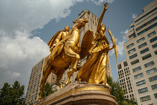 The golden statue of General William Tecumseh Sherman shines in the sunlight at Grand Army Plaza. Surrounded by historic and modern buildings, it is a striking landmark in New York.