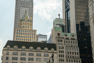 A beautiful contrast of architectural styles in Midtown Manhattan. Ornate historic facades meet sleek glass skyscrapers under a bright summer sky.