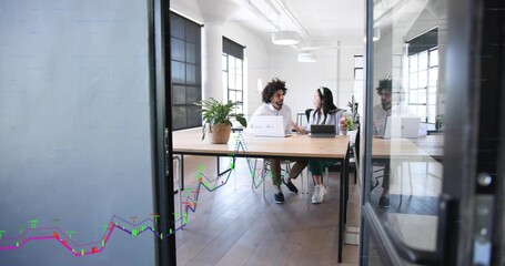 Discussing colleagues in white shirts gesturing over wood table in office with laptops tablet plant © vectorfusionart