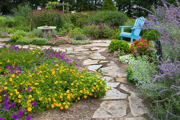 63821-19406 Flower garden with stone path, blue chair, birdbath. Homestead Purple Verbena, yellow lantana, Russian Sage, Gomphrena IL