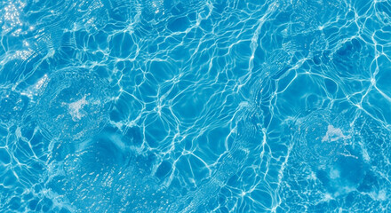 Obraz premium Clear pool water with ripples in bright blue tone with sunlight reflection for summer background